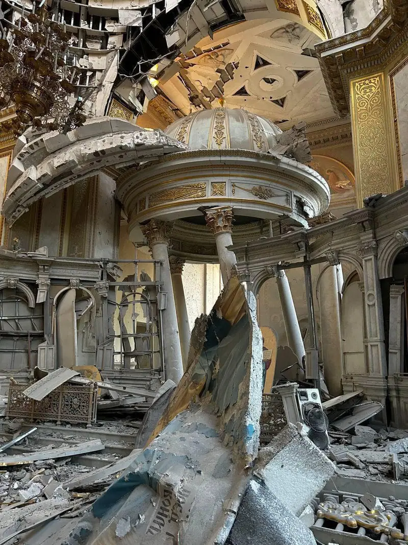 Interior of the Transfiguration Cathedral in Odesa with the roof torn open, collapsed plaster and twisted metal heaped in front of the altar canopy
