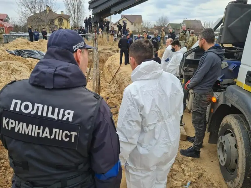 Ukrainian police investigators exhuming the bodies of Bucha residents from a mass grave