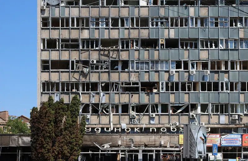 A tall office building in central Vinnytsia with almost all of its windows blown out and facade panels torn away
