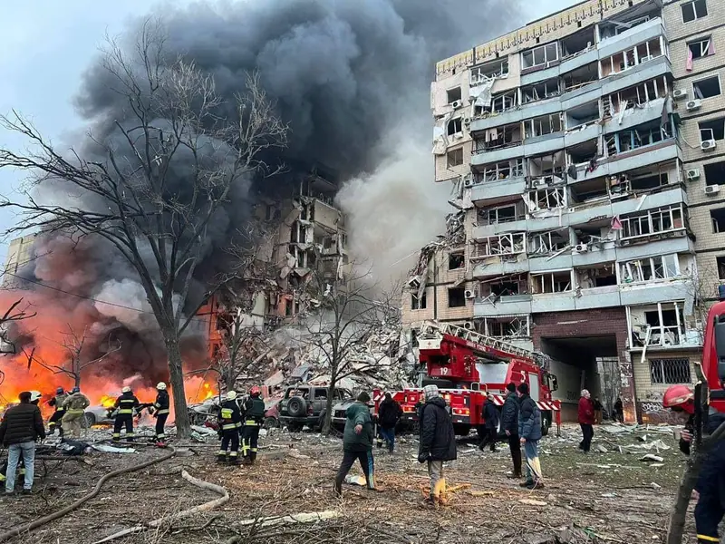 Firefighters work at a destroyed residential building in Dnipro on the day of the missile strike