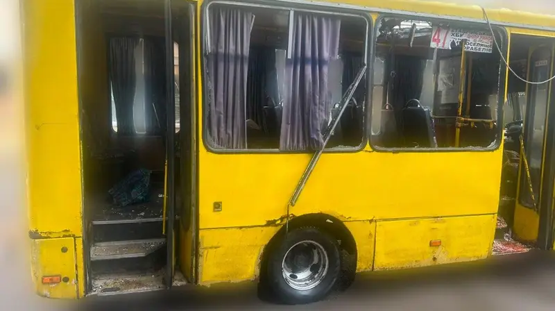 A yellow minibus on route 47 with shattered windows and an open door. The publisher blurred the bottom of the photo.